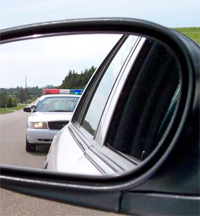 Police car in a car's rear view mirror